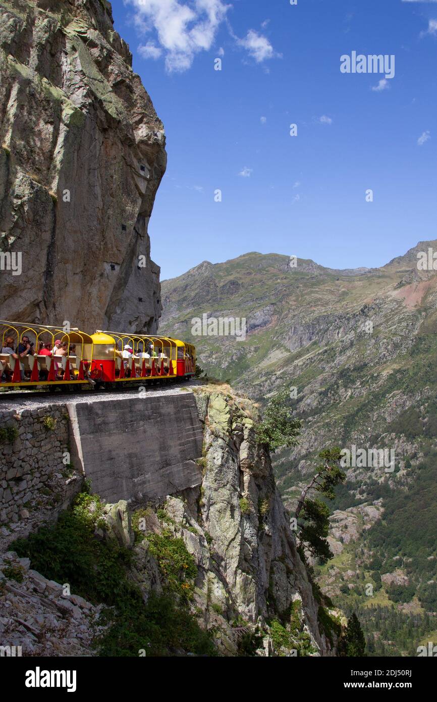 tourist train full of people running through a mountain gorge in the Pyrenees, Artouste France, vertical Stock Photo