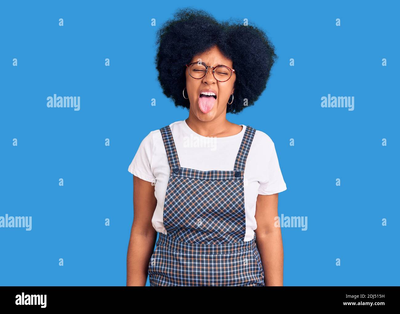Young african american girl wearing casual clothes sticking tongue out ...