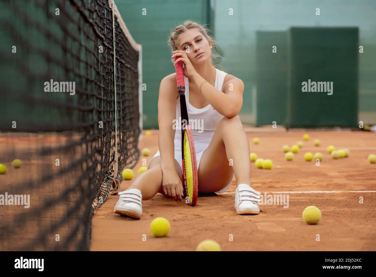 women, women outdoors, tanned, model, legs, standing, long hair, skirt,  white clothing, tennis rackets, sneakers, tennis court, sand