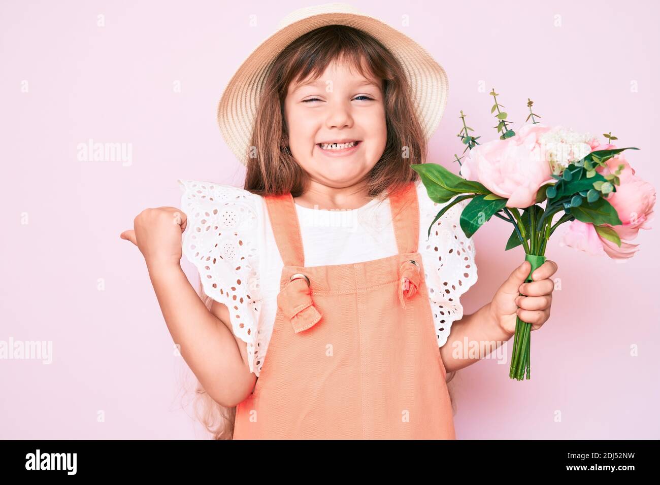 Little caucasian kid girl with long hair holding flower wearing spring ...
