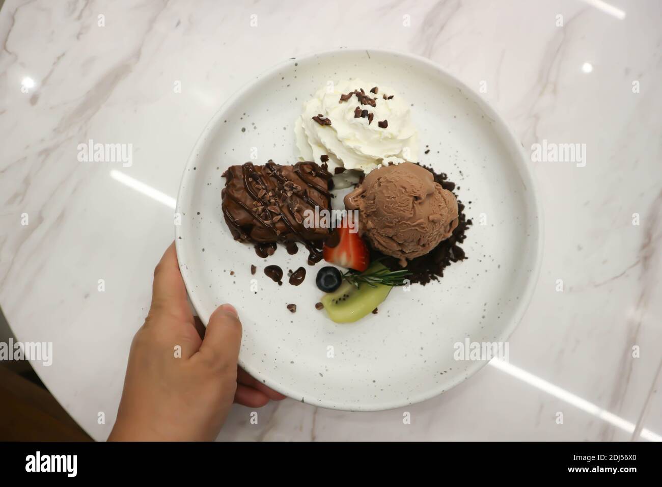 brownie , chocolate ice cream with whipping cream and fruit for serve Stock Photo