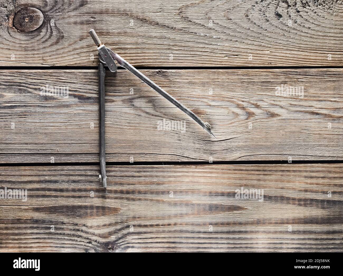 Metal compasses on a wooden table. Stock Photo