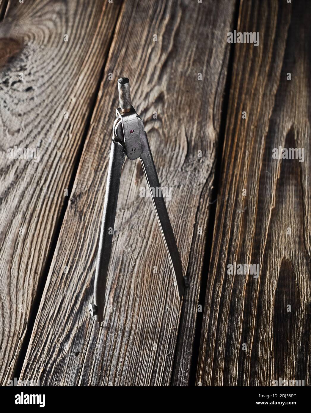 Metal compasses on a wooden table. Stock Photo
