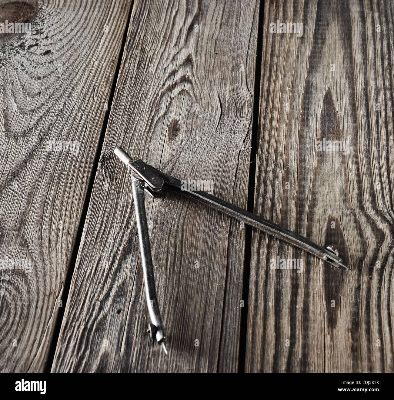 Metal compasses on a wooden table. Stock Photo