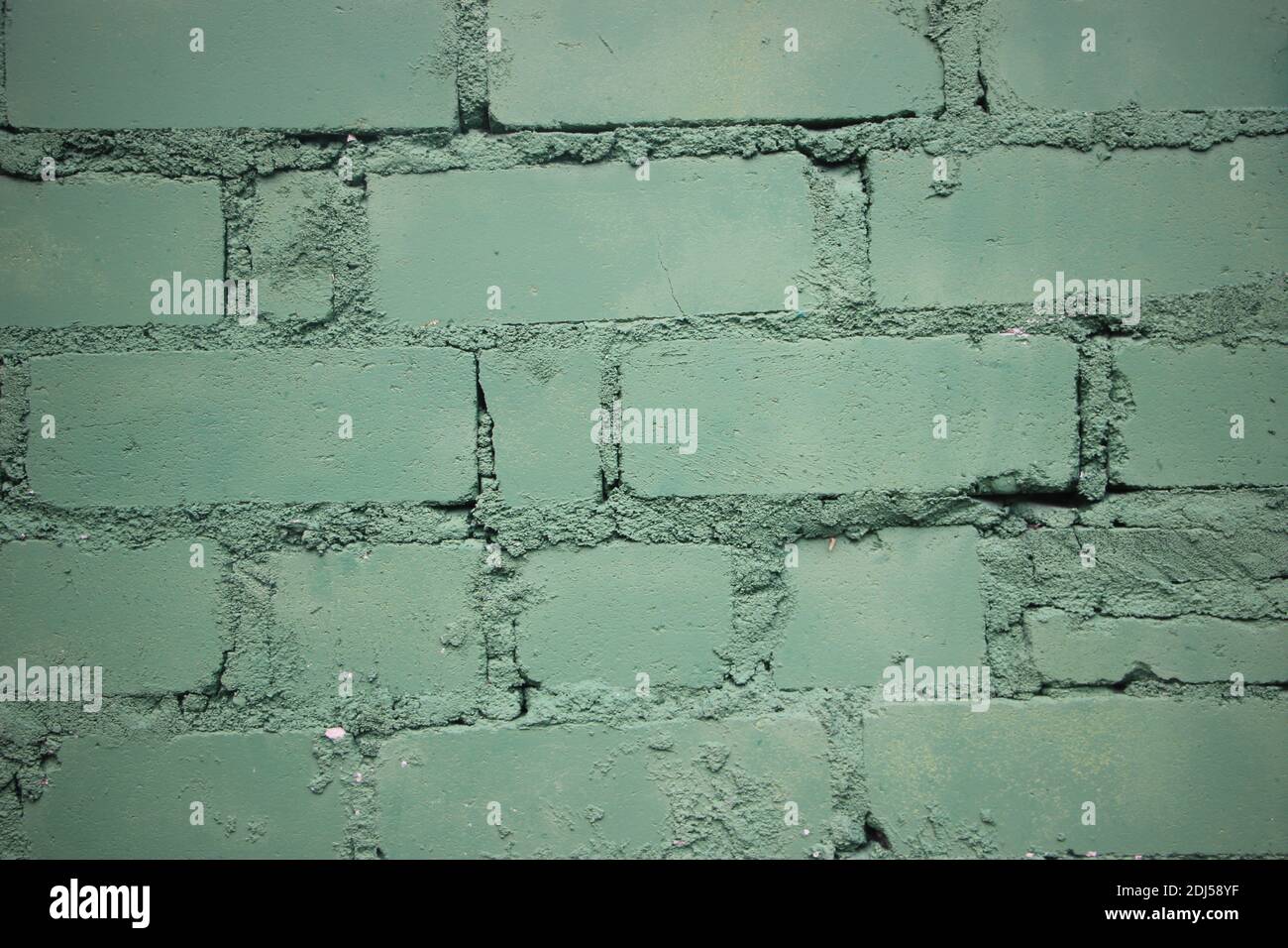 Painted into teal green Brick wall background closeup. Stock Photo