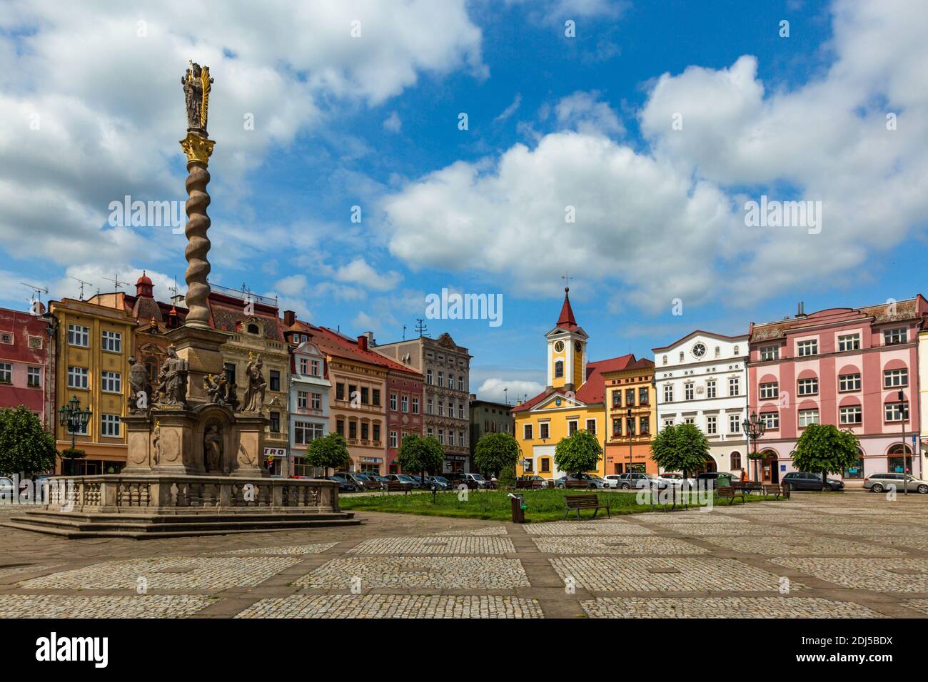Broumov, Czech Republic - June 17 2020: View of the town square with town hall, colourful houses, green lawn, trees and the Marian column with statues. Stock Photo
