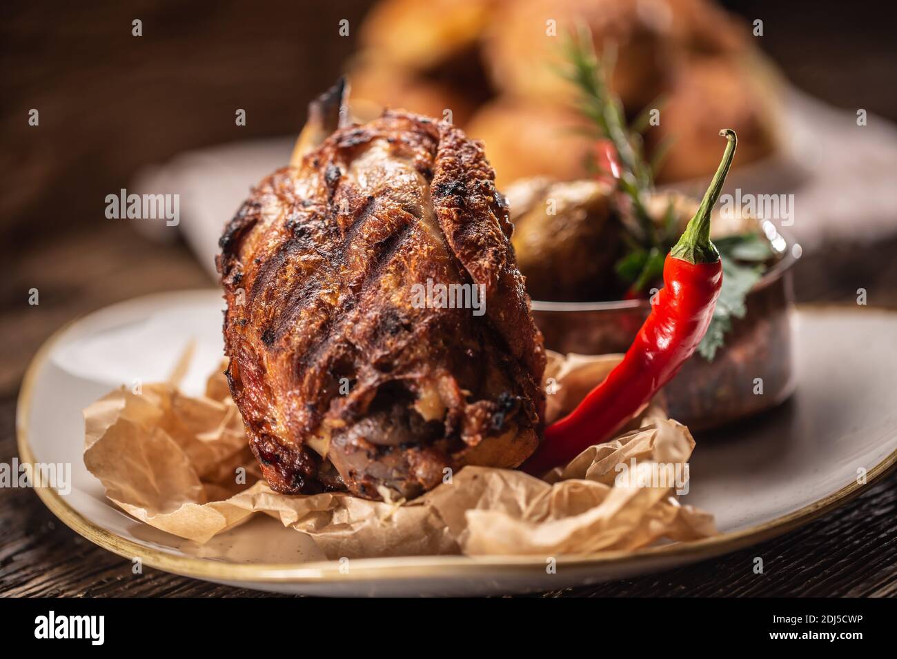 German pork knuckle served with chilli and baked potatoes. Stock Photo