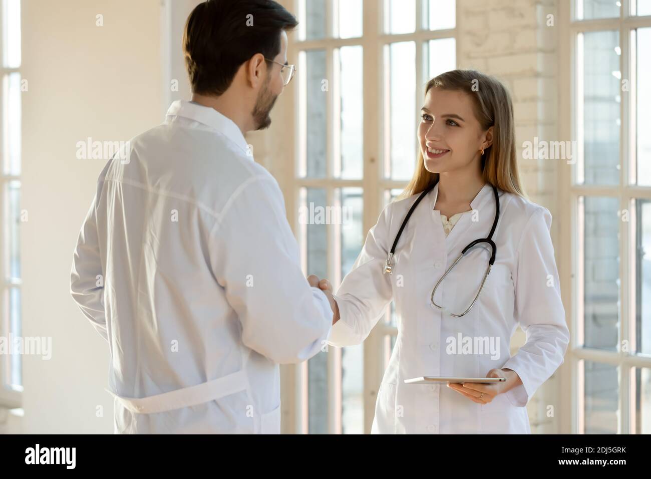 Smiling doctors handshake greeting in private hospital Stock Photo