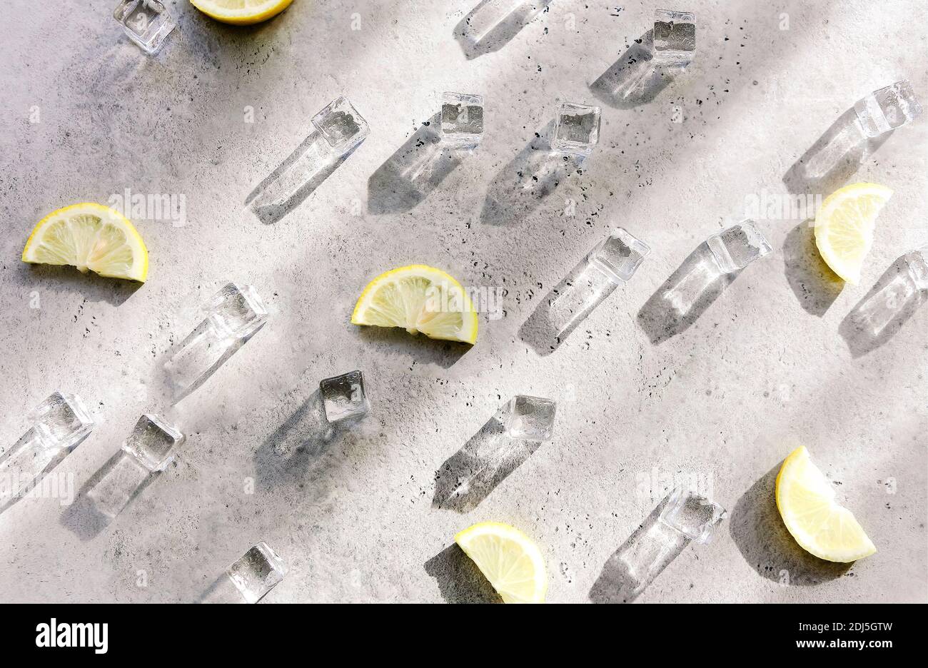 Ice cubes with droplets and lime on cement background. Summer background Stock Photo