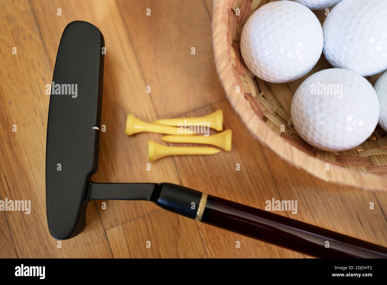 Golf club, golf balls and some tees on parquet floor Stock Photo