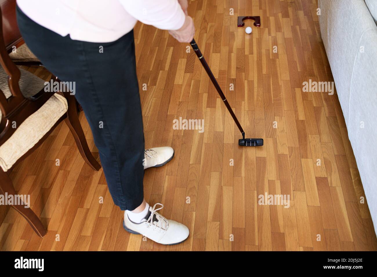 Woman playing mini golf at home. Stay at home concept Stock Photo