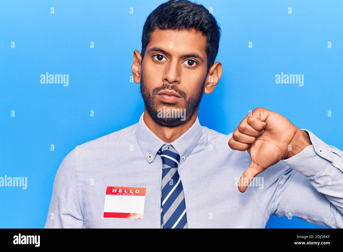 Young latin man wearing sticker with hello my name is message with ...