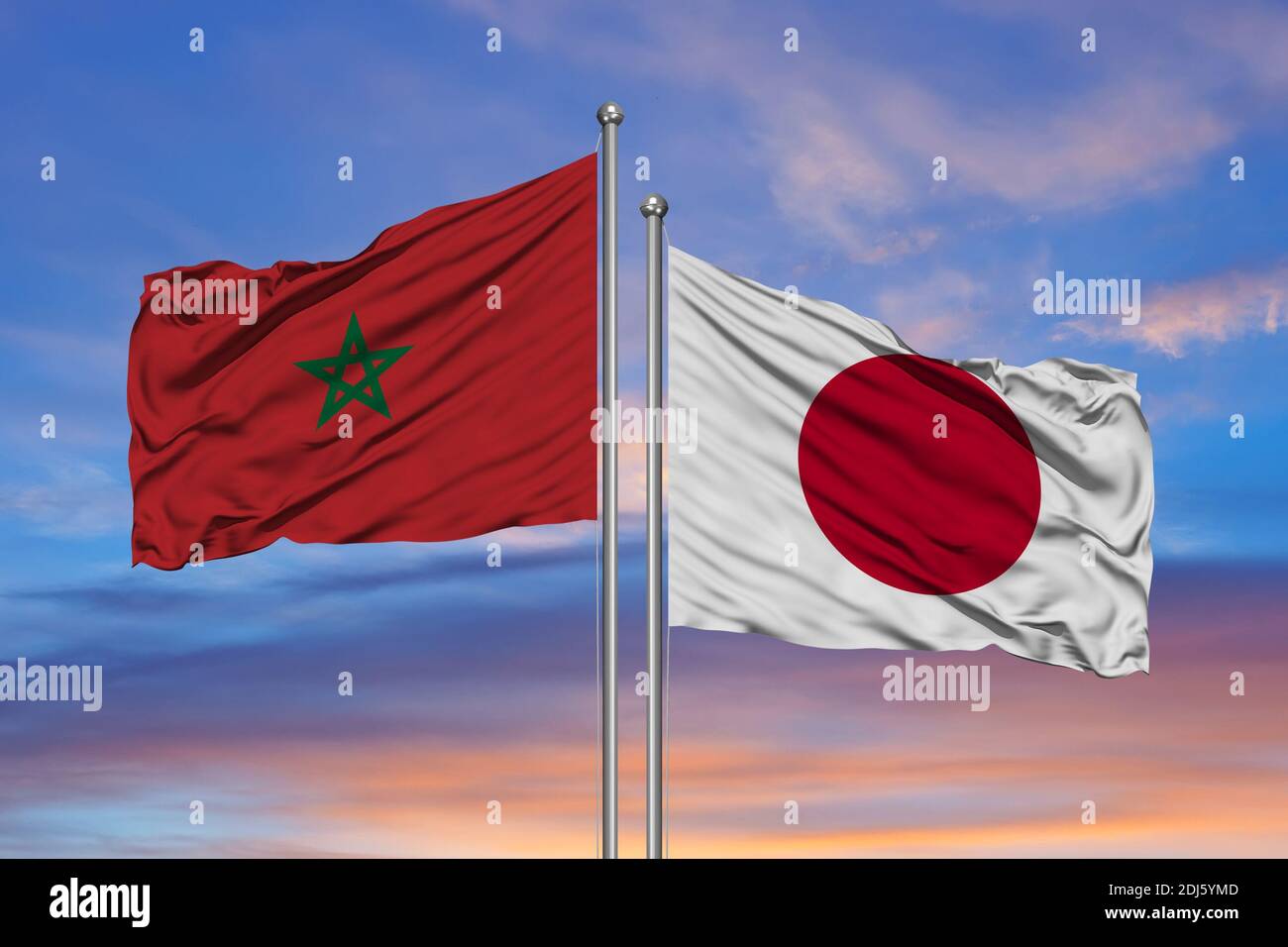 The flags of Morocco and Japan waving together in the blue sky Stock Photo