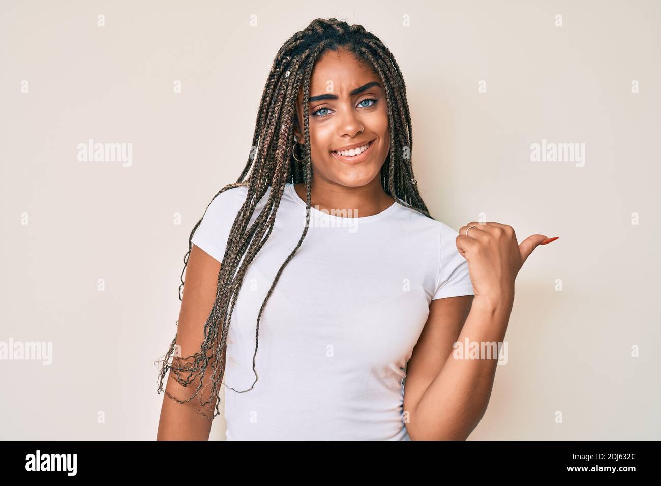 Young african american woman with braids wearing casual white tshirt ...