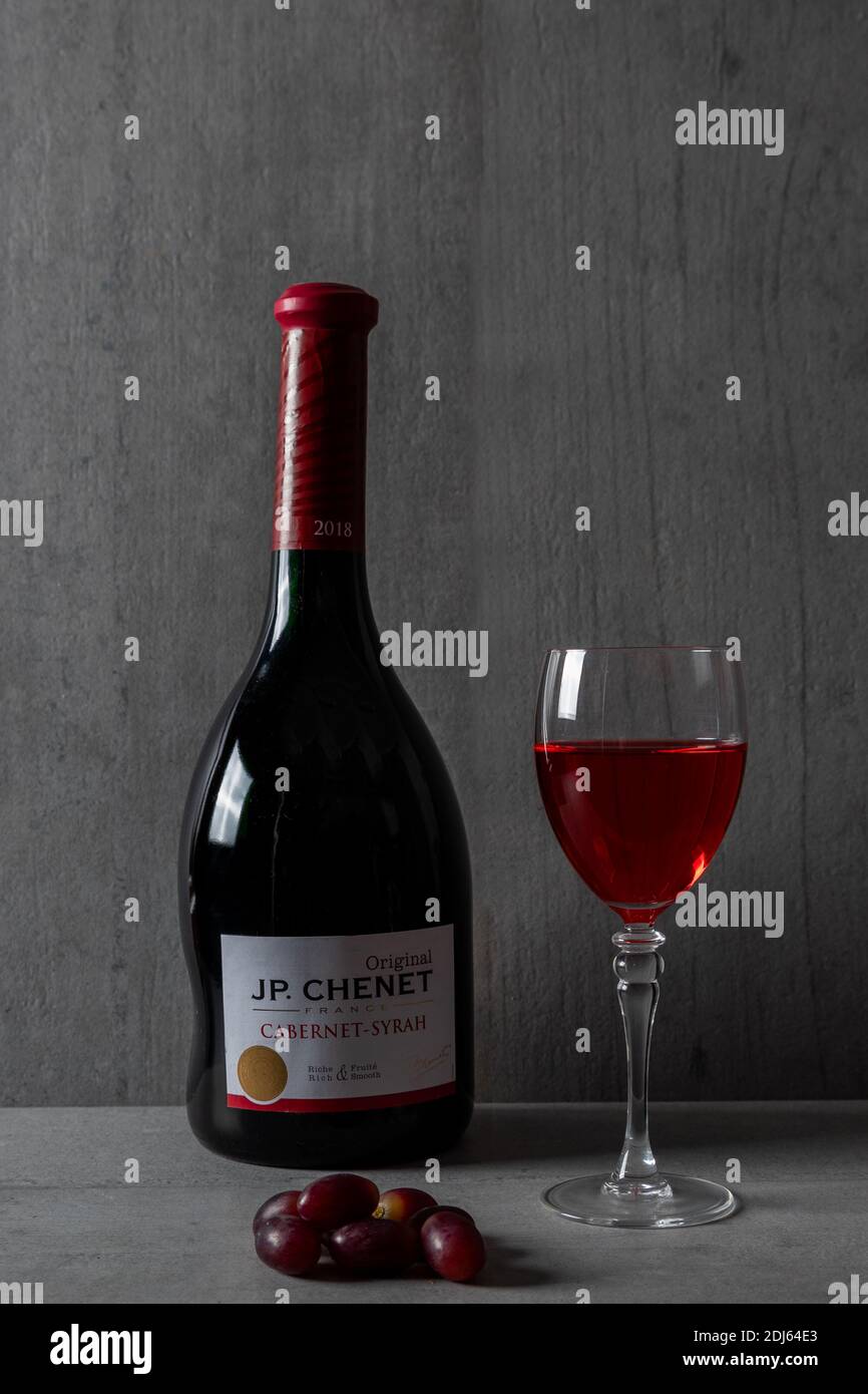 studio image of an unique bottle of JP. Chenet - Cabernet - Syrah with an  asymmetric neck of the bottle and a glass of red wine and grapes to  decorate Stock Photo - Alamy