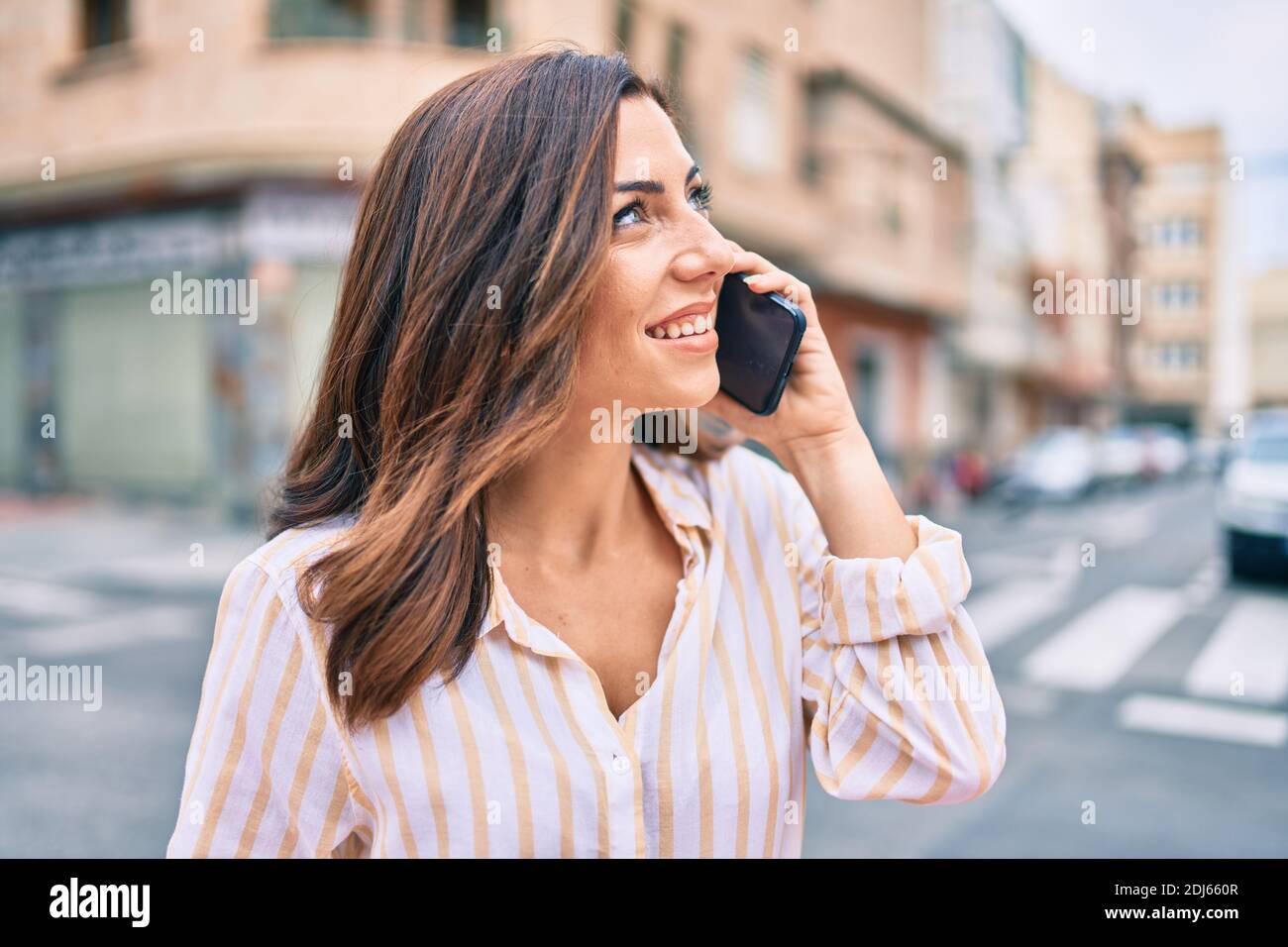 Young hispanic woman smiling happy talking on the smartphone at the ...