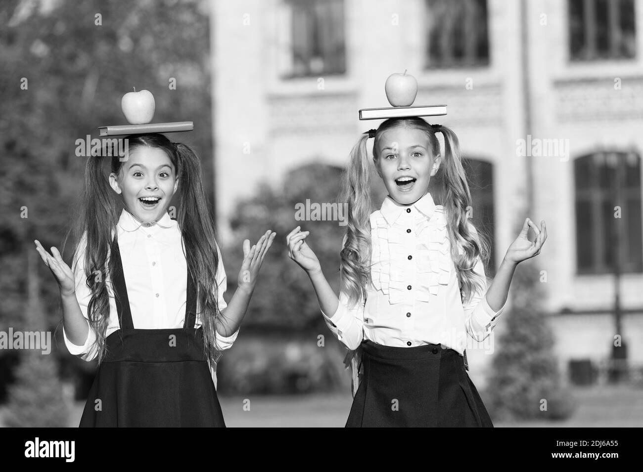 Imagination takes you everywhere. Happy kids hold books and apples on heads. Childhood imagination. School snack. Knowledge and food. Developing imagination. Imagination and fantasy. Relax and create. Stock Photo