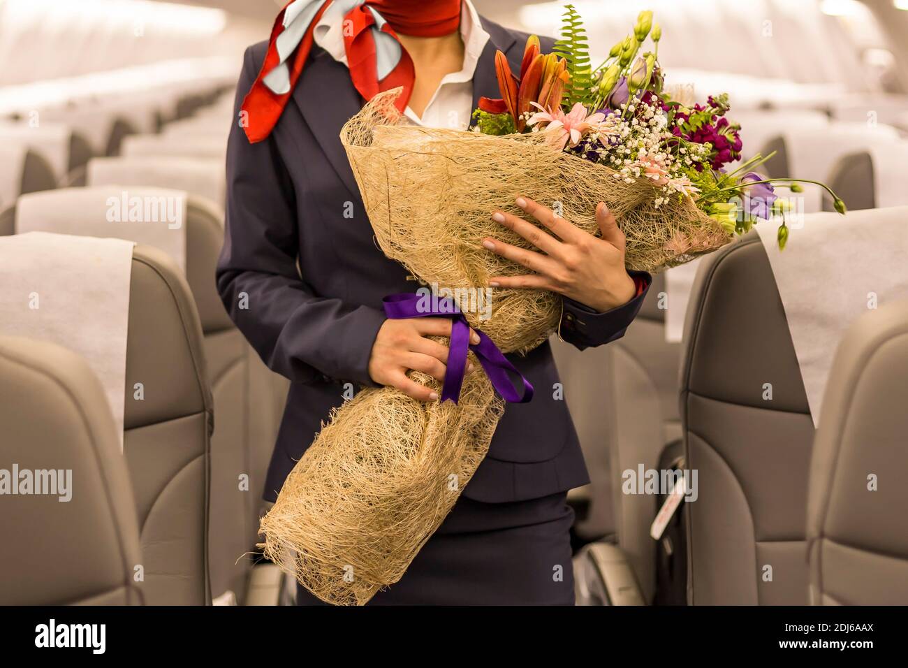 a flight attendant holding a bunch of flowers in her hand inside the