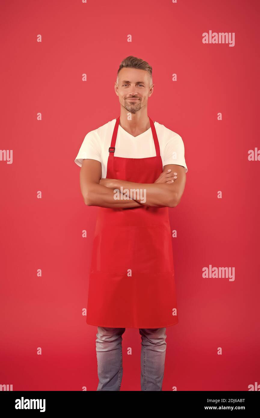 hospitable and confident husband. man in apron at kitchen. handsome