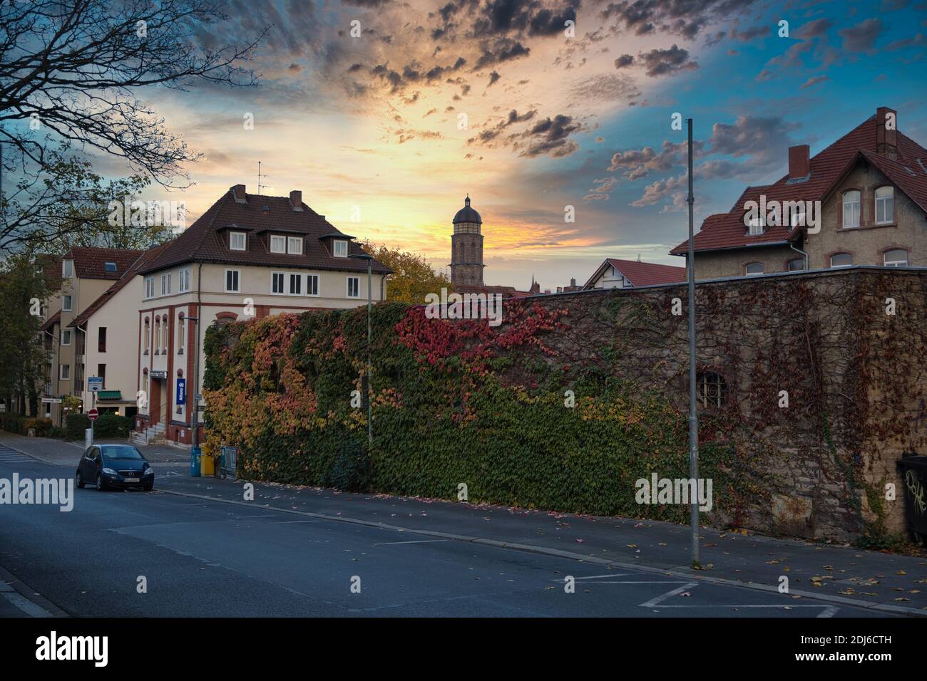 Göttingen, Germany. Street with ivy covered building and picturesque morning sky. Wide shot. Stock Photo