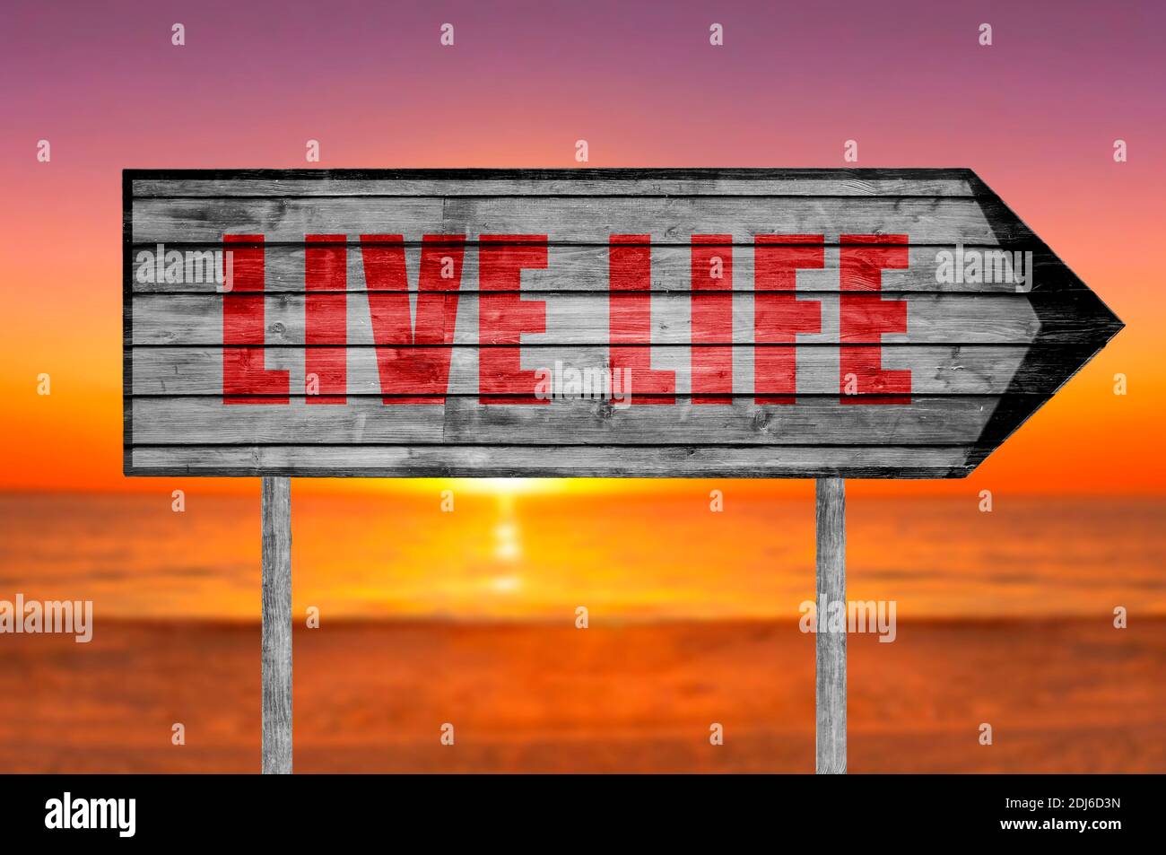 Red Live Life wooden sign with a beach on background Stock Photo