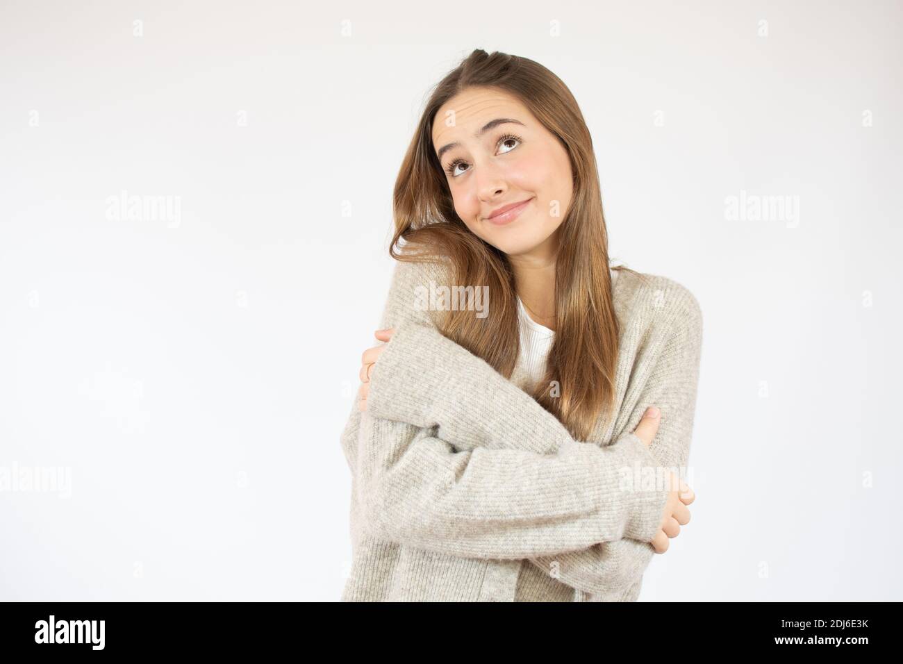 Young beautiful woman wearing sweater over white isolated background Hugging oneself happy and positive, smiling confident. Self love and self care Stock Photo