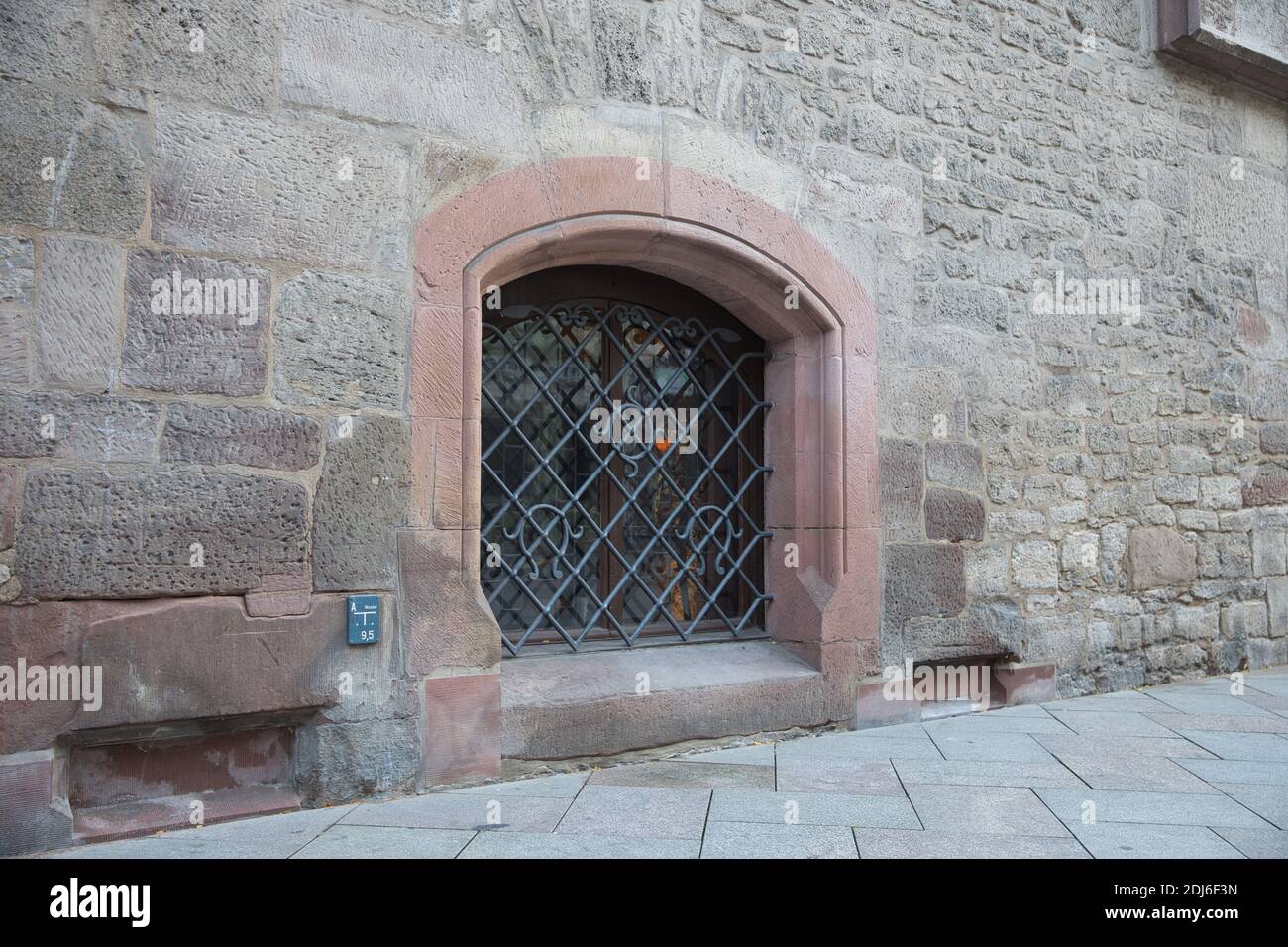 Basement window of medieval building barred with wrought metal. Göttingen German. Stock Photo
