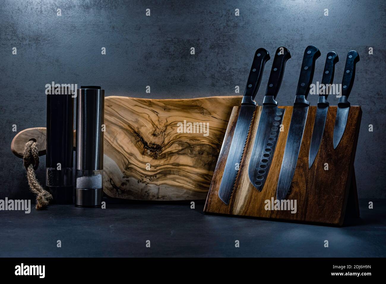 Kitchen knives, wooden cutting board and pepper and salt grinders Stock Photo