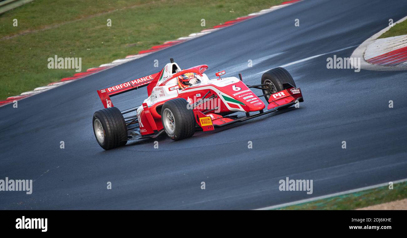 Racing car single seater modern formula in action at turn on wet asphalt circuit track Stock Photo