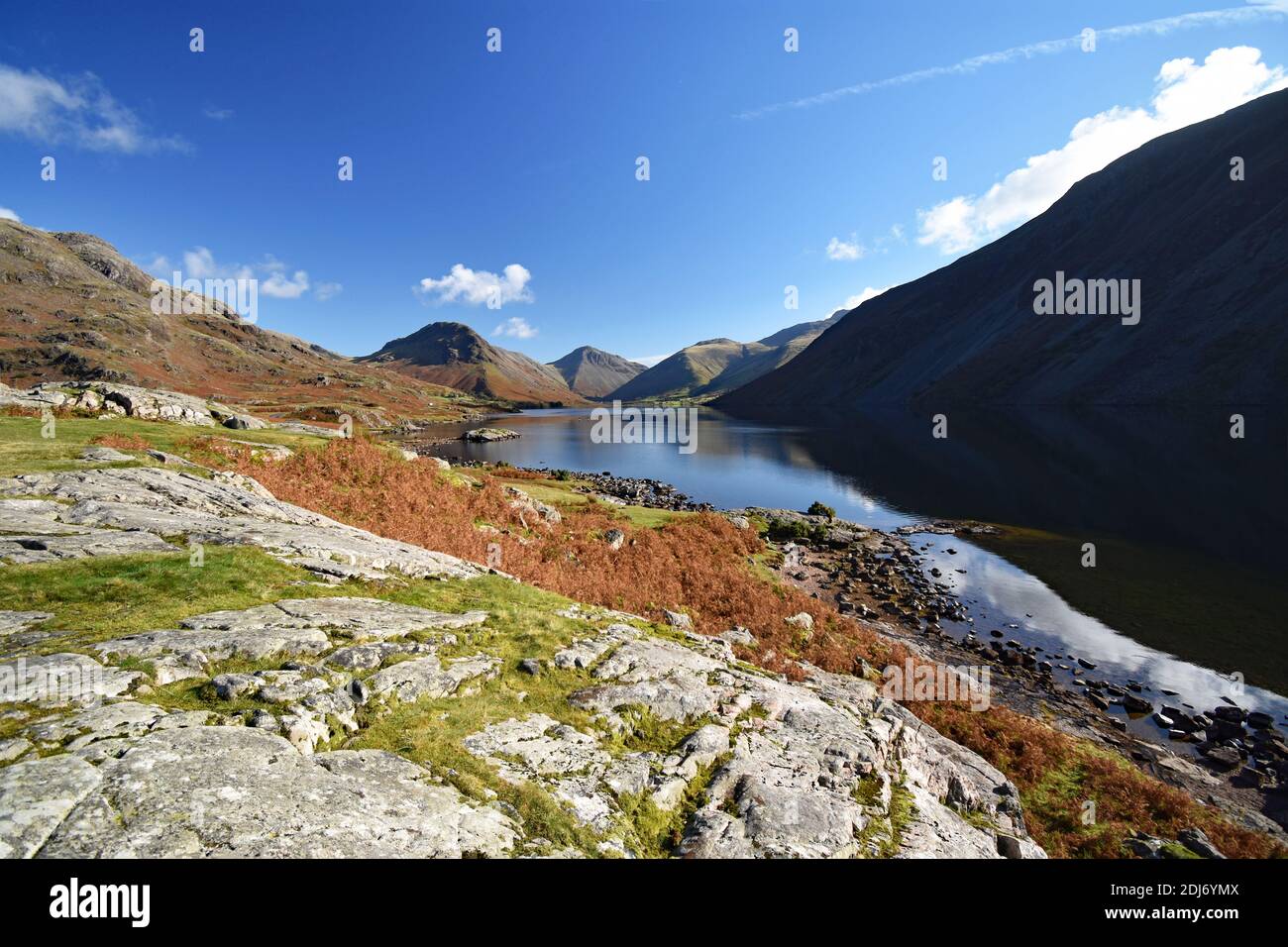 Wast Water or Wastwater Lake in the Lake District National Park, England. Autumn colours on the mountains and foliage. Sun position casts a shadow. Stock Photo