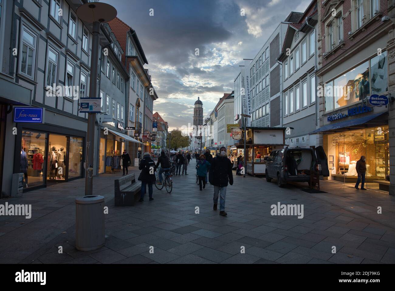 Göttingen Germany. Autumn, 2020. Pedestrian shopping zone with illuminated stores and scenic cloudscape in vanishing point. Stock Photo
