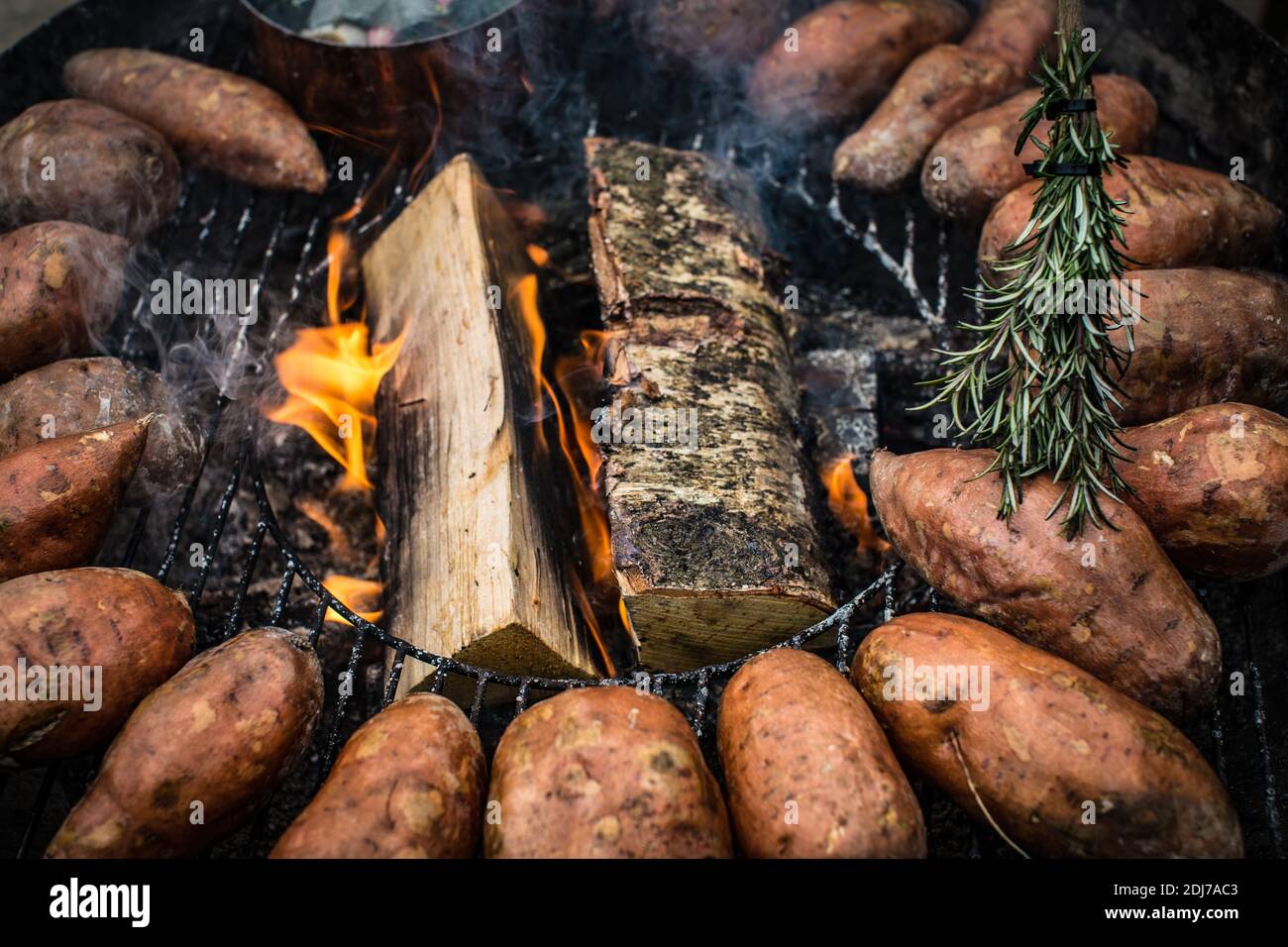 Fresh Whole Sweet Potatoes  cooking on a Grill Stock Photo