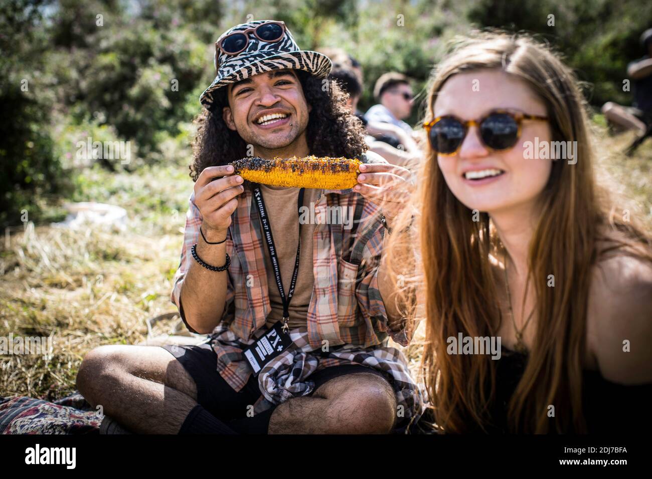 GREAT BRITAIN / England / Hertfordshire /Happy man with friend eating corn on the cob at food festival in England. Stock Photo