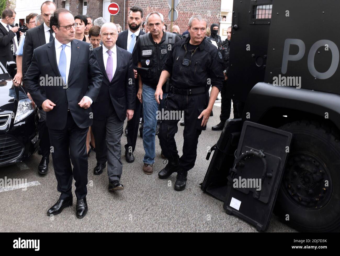French President Francois Hollande (L), followed by French Interior Minister Bernard Cazeneuve (C) and Head of the RAID, the French national police intervention group Jean-Michel Fauvergue (R), arrives in Saint-Etienne-du-Rouvray, western France on July 26, 2016, after a hostage-taking at a church of the town that left the priest dead. Two men who attacked a church and slit the throat of a priest had 'claimed to be from Daesh', using the Arabic name for the Islamic State group. Police said they killed two hostage-takers in the attack in the Normandy town of Saint-Etienne-du-Rouvray, 125 kilome Stock Photo