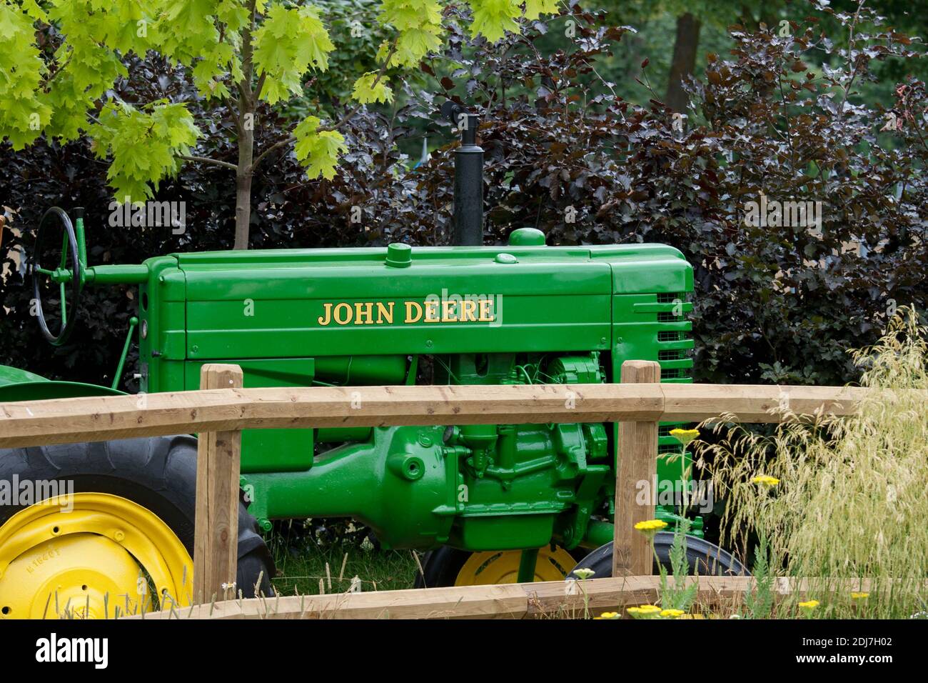 A restored vintage John Deere tractor behind a wooden fence Stock Photo ...