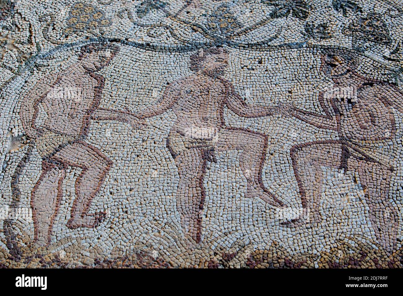 Merida, Spain - December 13th, 2020: Autumn mosaic. It depicts three men crushing grapes to make wine. Amphitheatre House. Merida, Spain Stock Photo