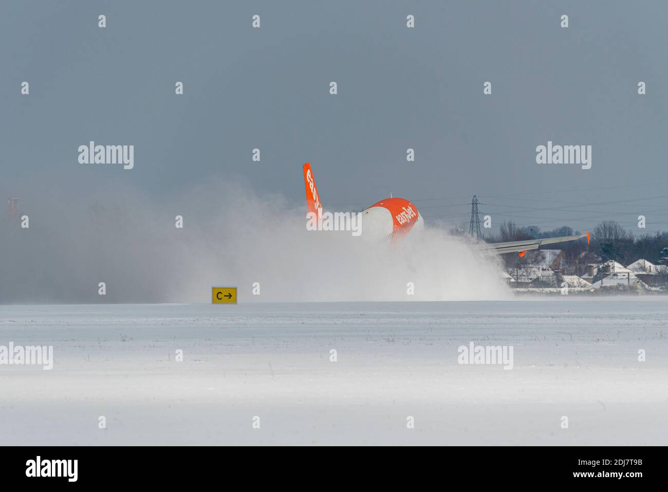 Snow covered London Southend Airport, Essex, UK, with an easyJet jet airliner plane throwing up a cloud of snow as it takes off. Plume of snow Stock Photo