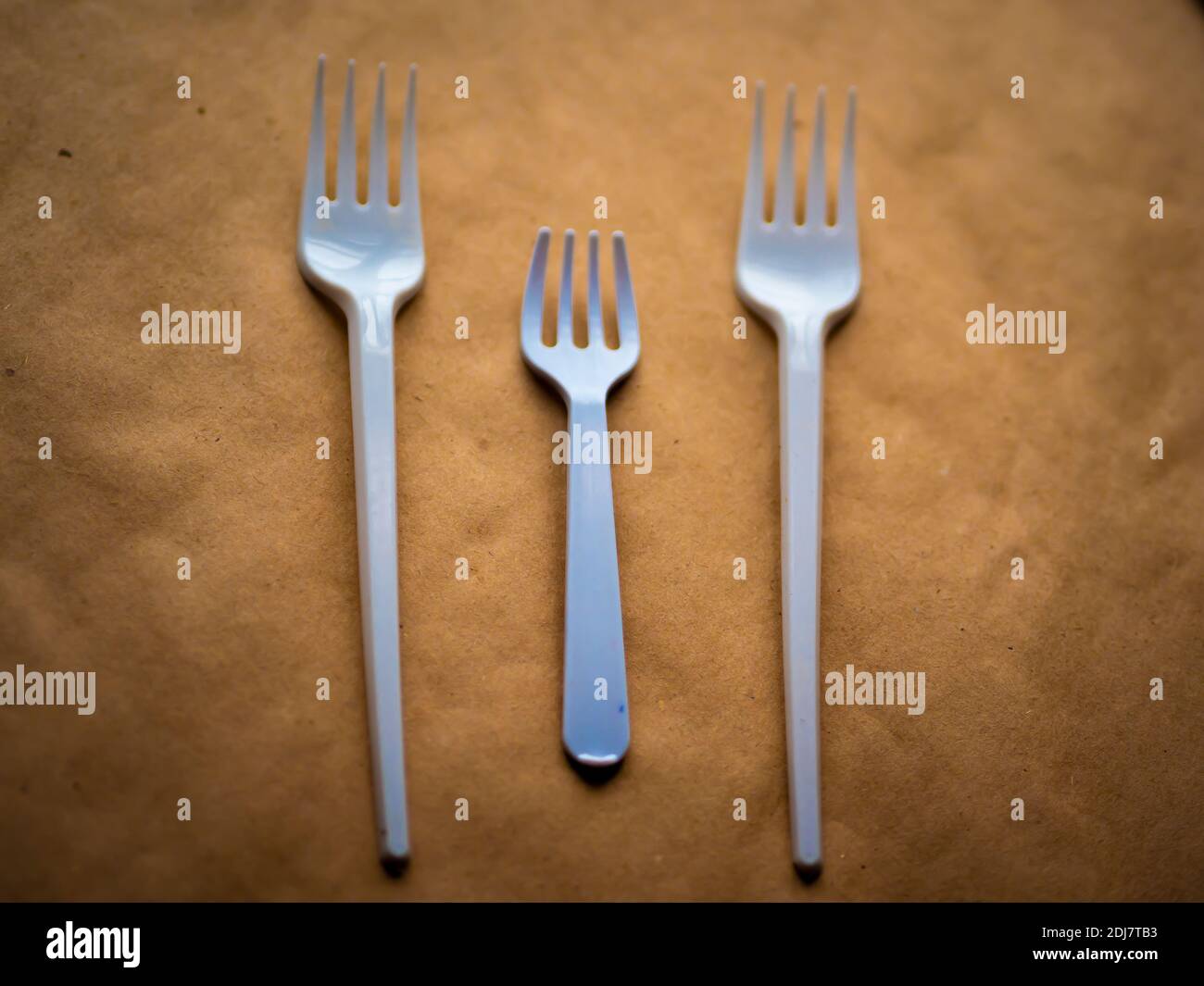 disposable tableware, red spoons forks knives on a yellow background top view Stock Photo