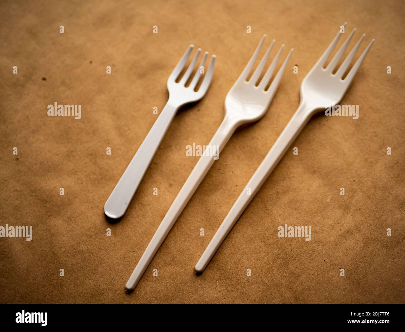 disposable tableware, red spoons forks knives on a yellow background top view Stock Photo