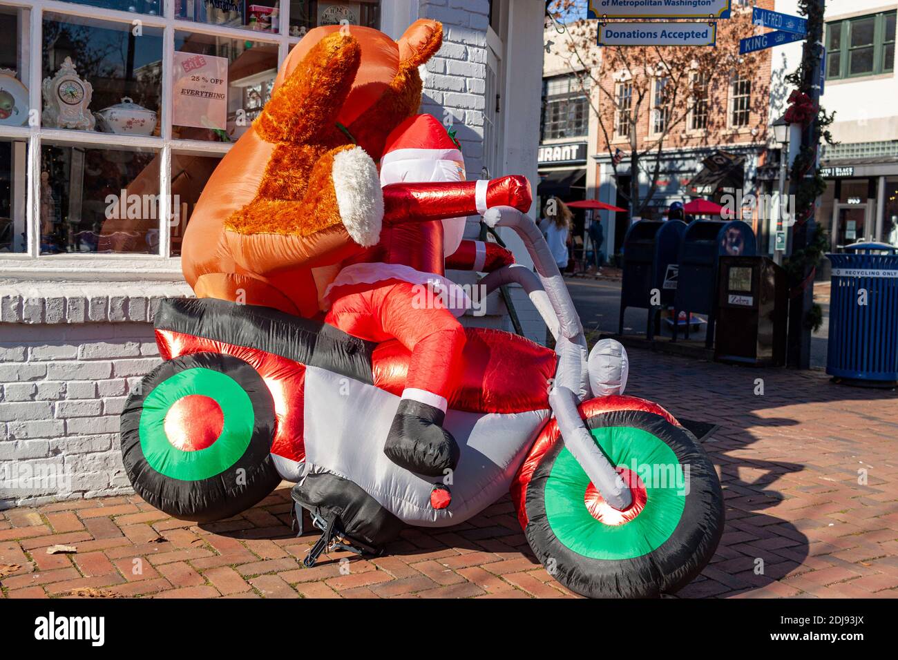 Alexandria, VA, USA 11-28-2020:  a creative Christmas decor in front of a gift shop featuring a big inflatable Santa Claus toy riding on a motorbike w Stock Photo