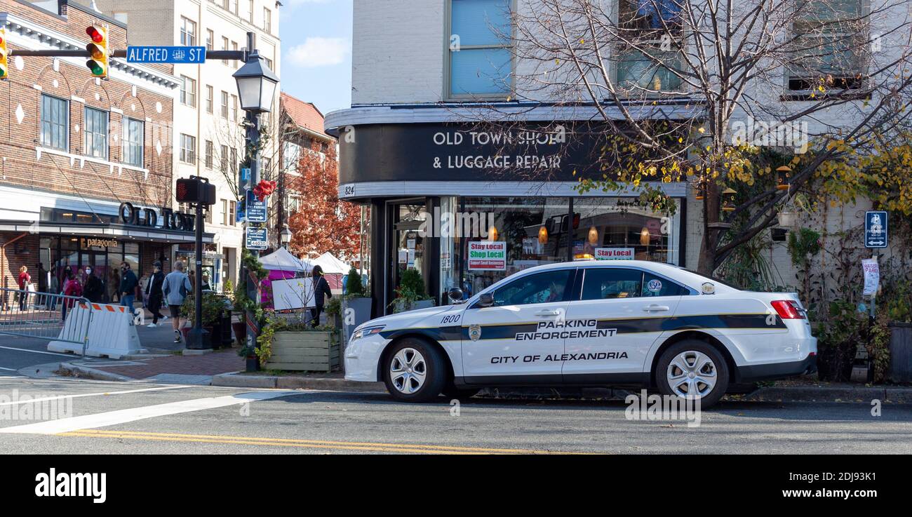 Alexandria, VA, USA 11-28-2020: A view of downtown Alexandria with shops and people on street. A white police car used by Parking Enforcement Officers Stock Photo