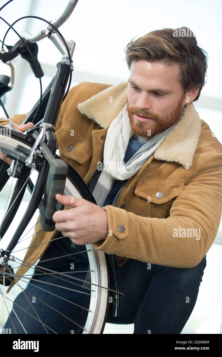 closeup image of man locking his bicycle on street Stock Photo - Alamy