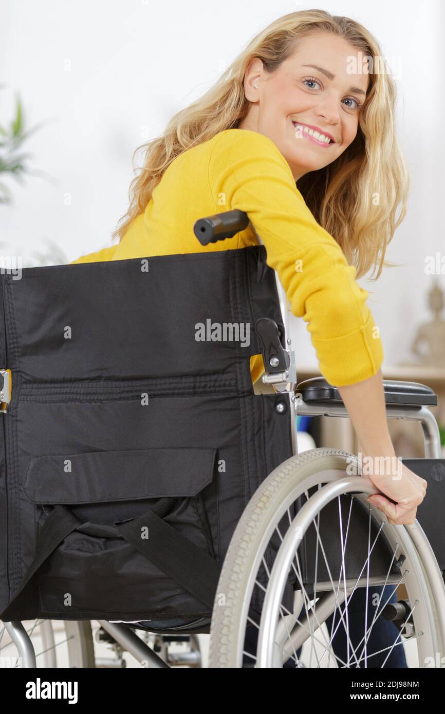 young woman sitting on wheelchair smiling Stock Photo - Alamy
