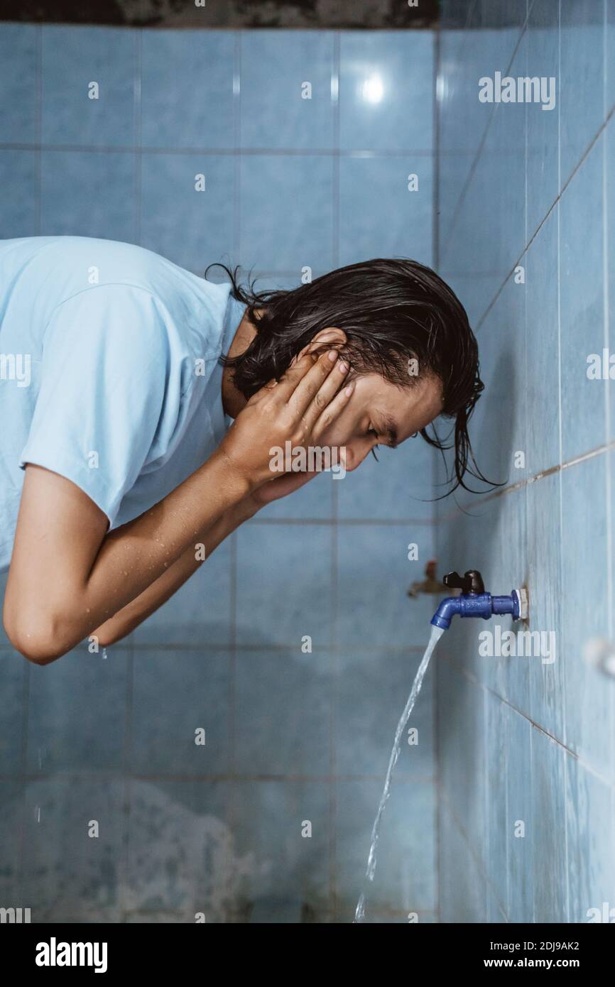 Man muslim perform ablution (wudhu) washing ear before prayer Stock