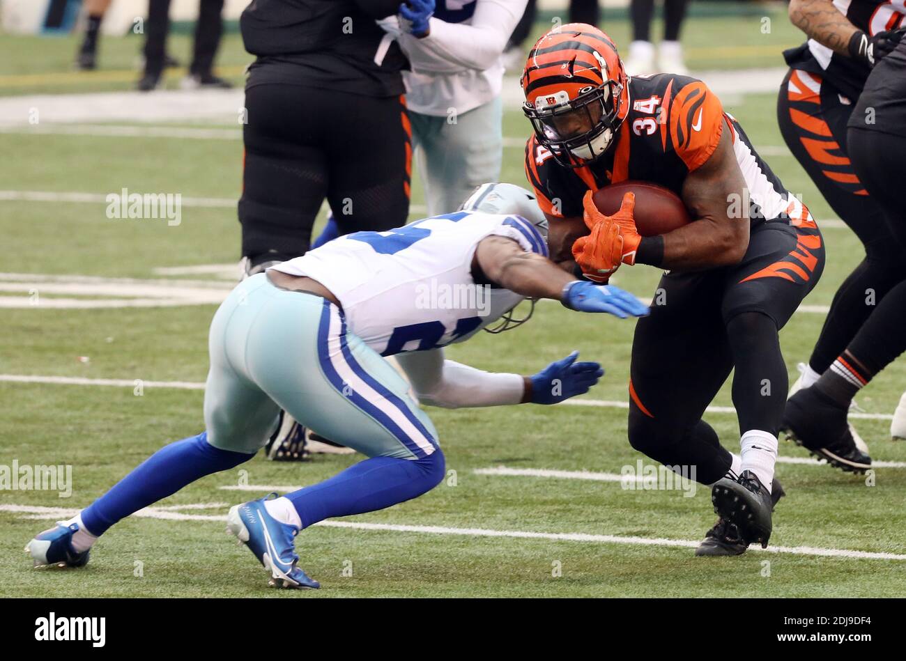 Cincinnati, United States. 13th Dec, 2020. Cincinnati Bengals halfback Samaje Perine (34) is tackled by Dallas Cowboys' Xavier Woods (25) during the first half of play at Paul Brown Stadium in Cincinnati, Ohio, Sunday, December 13, 2020. Photo by John Sommers II/UPI Credit: UPI/Alamy Live News Stock Photo