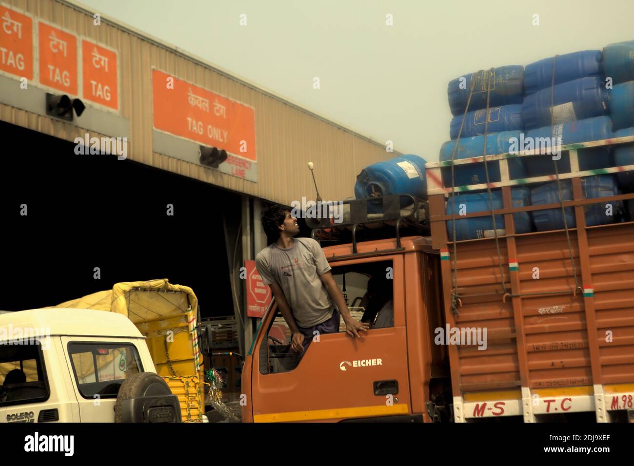 Expedition worker checking truckload before passing a toll gate in Delhi,  India Stock Photo - Alamy