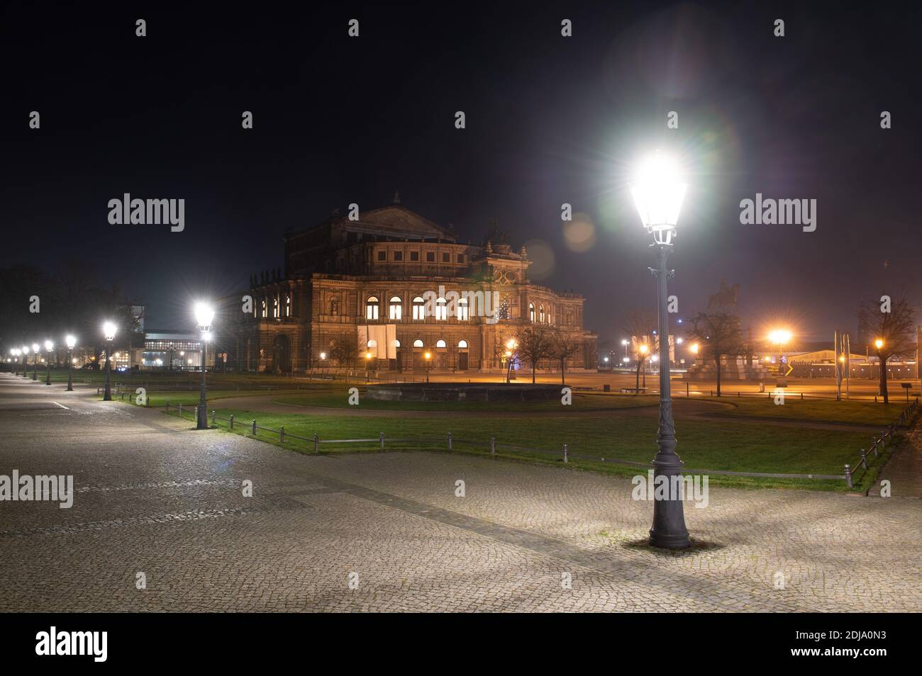 Dresden, Germany. 14th Dec, 2020. The Semper Opera House with the empty Theaterplatz is framed by street lamps in the early morning. Saxony will go into a hard lockdown from 14 December 2020. Public life remains shut down until January 10, 2021. In addition to most shops, day-care centres, schools and after-school care centres are also closed. As in spring, emergency care is available for children of parents of systemically important professions. The Free State of Bavaria is considered a Corona focal point nationwide. Credit: Sebastian Kahnert/dpa-Zentralbild/dpa/Alamy Live News Stock Photo