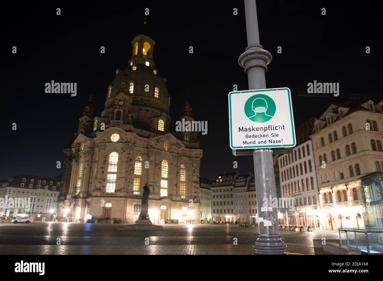 Dresden, Germany. 14th Dec, 2020. A sign indicating that masks are compulsory hangs on the empty Neumarkt in front of the Frauenkirche. Saxony will go into a hard lockdown from 14 December 2020. Public life will remain shut down until January 10, 2021. In addition to most shops, day-care centres, schools and after-school care centres are closed, and emergency care is available for children of parents of systemically important professions, as in spring. The Free State of Bavaria is considered a Corona focal point nationwide. Credit: Sebastian Kahnert/dpa-Zentralbild/dpa/Alamy Live News Stock Photo