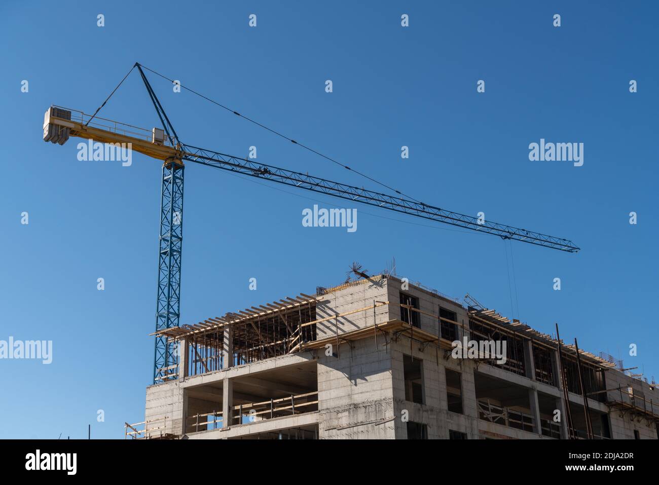Construction of a building with a remotely controlled unmanned crane Stock Photo