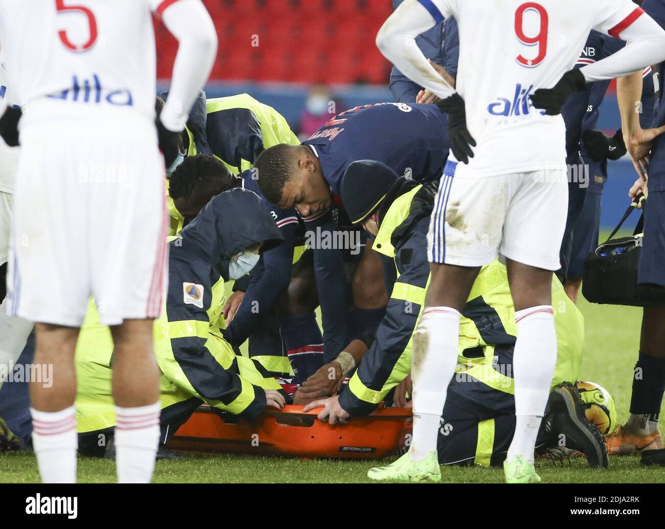 Neymar Jr of PSG, injured with a sprained ankle and consoled by Kylian Mbappe, leaves the pitch on a stretcher during the French / LM Stock Photo